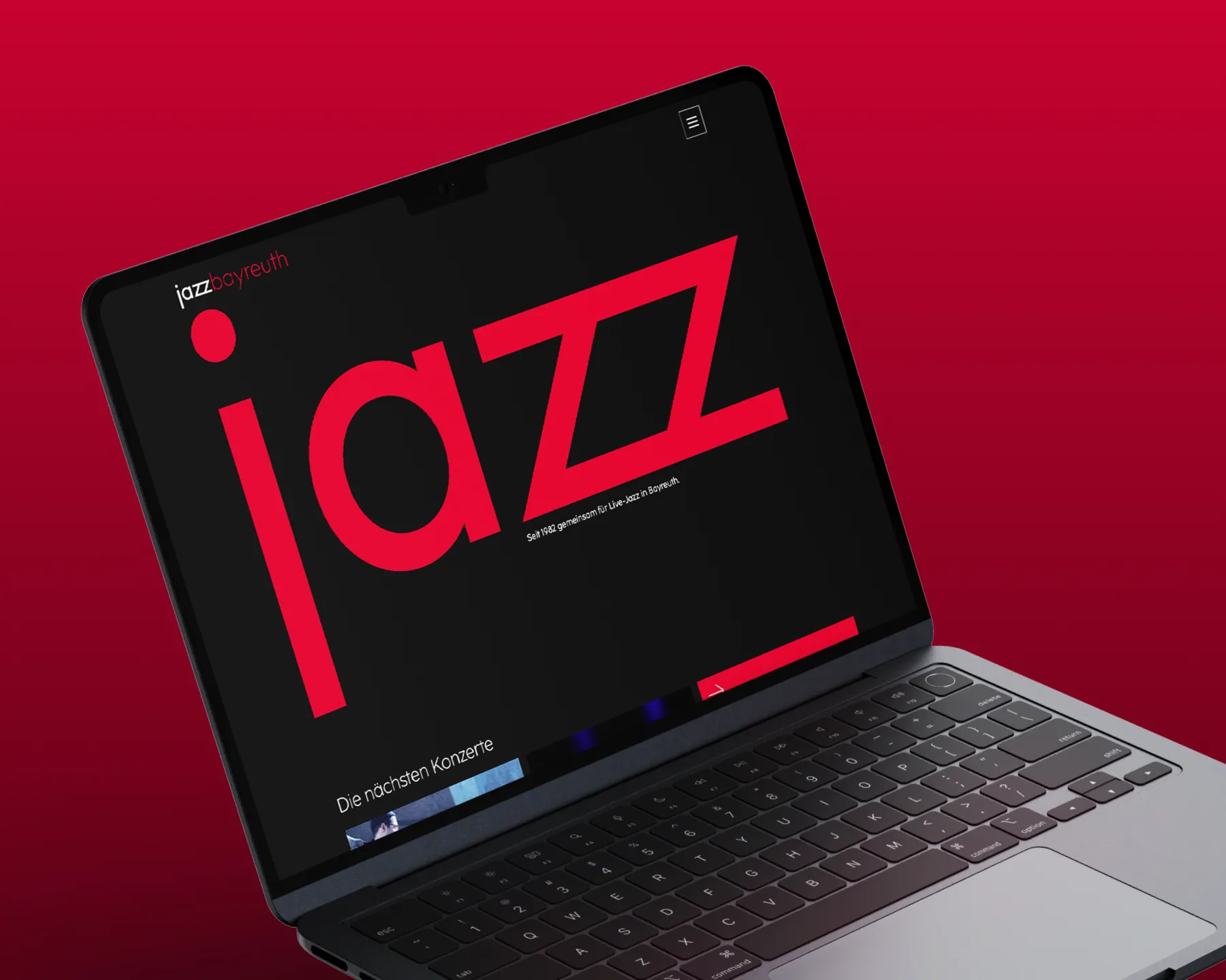 Ein geöffneter Laptop zeigt die Startseite der Website des Jazzforum Bayreuth mit dem Logo auf dunklem Hintergrund.