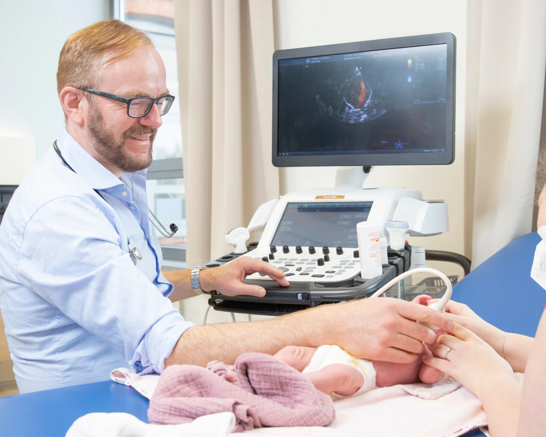 Professionelles Praxis-Foto einer Ultraschall-Untersuchung bei einem Säugling für den Online-Auftritt.