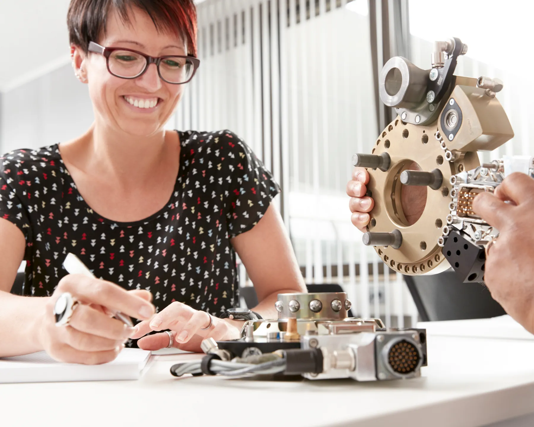 Mitarbeiterin arbeitet praktisch an einem modularen Roboter-Werkzeugwechselsystem.